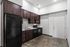 Modern kitchen with sleek dark wood cabinets, high-quality appliances, and polished concrete floor.