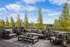 Chic outdoor patio with modern seating, lush greenery views, and a serene atmosphere, perfect for relaxing or entertaining.