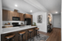 Modern kitchen with sleek countertops, wooden cabinetry, and stylish bar stools, perfect for entertaining.