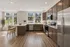 Bright and inviting kitchen with elegant wood cabinetry, sleek stainless steel appliances, and expansive windows offering lush green views.