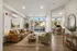 Bright and modern living room with large windows offering a scenic view, and a cozy workspace corner, perfect for comfortable living.
