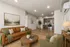 Inviting open-concept living area with elegant wooden flooring, featuring a modern kitchen with stainless steel appliances.