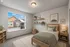 Cozy and bright bedroom with large window offering a charming neighborhood view, enhancing the room's warmth and natural light.