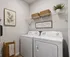Chic laundry room with modern washer and dryer, and wire shelving creating a functional and inviting space.