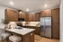 Charming kitchen with modern stainless steel appliances, elegant wooden cabinetry, and a stylish breakfast bar for cozy meals.