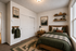 Cozy bedroom with nature-inspired decor, featuring earthy tones, mountain artwork, and a plush bed with forest-themed bedding.