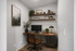 Elegant home office space featuring a wooden desk, leather chair, and wall-mounted shelves with decor and plants, perfect for productivity and style.