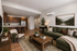 Elegant open-concept living space featuring comfortable seating, stylish decor, and a modern kitchen with rich wooden cabinetry.