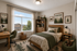 Cozy bedroom featuring a nature-themed decor with woodland accents, a large window offering picturesque views, and warm, inviting furnishings.
