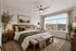 Inviting bedroom with elegant decor, featuring a plush bed, stylish lighting, and large window with scenic views.