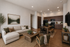 Inviting open-concept living room and kitchen featuring elegant decor, cozy seating, and warm wooden cabinetry.