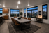 Modern dining area with chic decor, large windows showcasing a stunning cityscape view, and sleek wooden cabinetry.