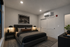 Luxurious bedroom with modern decor featuring a plush king-sized bed, ambient lighting, and elegant cityscape artwork.