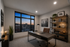 Sophisticated home office with a modern desk, elegant shelving, and a stunning city view at sunset.