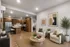Elegant modern living room with open kitchen, featuring wood cabinets, stainless steel appliances, and plank floors. Bright and inviting space perfect for relaxation and entertaining.