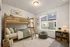 Charming bedroom featuring a sunlit window and soft lighting.