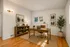 Elegant home office with a wooden desk, stylish decor, and natural light streaming through the window, creating a serene and productive workspace.