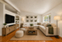 Bright and inviting living room with modern furnishings, cozy sectional sofa, and stylish wooden accents, ideal for relaxation.