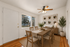 Bright and inviting dining room with stylish wooden furniture, large window view, and artistic decor, perfect for family gatherings.