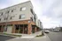 Chic urban mixed-use apartment building with mixed brick and modern facade, offering convenience and style in a vibrant neighborhood.