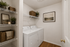 Elegant laundry room with modern washer and dryer, stylish shelving for storage, and tasteful decor creating a warm, functional space.