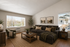 Cozy and elegant living room featuring a plush sectional sofa, large windows with park views, and chic, natural decor elements.