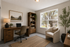 Inviting home office featuring a wooden desk with a laptop, comfortable chair, and large window providing serene outdoor view.