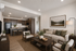 Contemporary open-concept living room featuring a cozy seating area and modern kitchen with sleek wooden cabinetry, perfect for entertaining.
