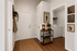 Inviting apartment entryway featuring elegant decor, woven rug, and convenient laundry room access.