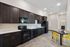 Sleek and modern kitchen with dark wood cabinetry, stainless steel appliances, and vibrant yellow dining chairs.