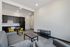 Modern open-concept living space featuring a cozy seating area, sleek kitchen with dark cabinets, and vibrant yellow dining chairs.