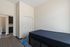 Modern bedroom with sleek furniture, ample closet space, and a glimpse into a chic ensuite bathroom, perfect for comfortable living.