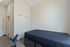 Modern bedroom with sleek minimalist design, featuring a comfortable bed, spacious closet, and functional workspace.