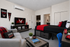 Stylish studio apartment showcasing a modern living area with vibrant decor, cozy bed, and wall-mounted TV, perfect for urban living.