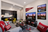 Modern living room with cozy Eastern Washington University-themed decor, featuring a sleek kitchen, vibrant yellow chairs, and stylish wall art, creating a welcoming collegiate atmosphere.