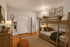 Cozy bedroom featuring elegant wooden bunk beds, warm lighting, and a rustic themed decor with fishing accents and natural wood flooring.