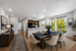 Modern open-concept dining and kitchen area with elegant decor, natural light, and wooden finishes.