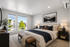 Bright and inviting bedroom with large windows offering scenic views, elegant decor, and cozy lighting.