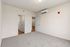 Inviting bedroom with plush carpet, modern air conditioning, and sleek white doors leading to an adjacent room.