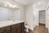 Modern bathroom with sleek fixtures, warm wood cabinetry, and elegant flooring.