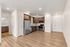 Contemporary open-concept kitchen with sleek hardwood floors, wooden cabinetry, and modern stainless steel appliances.
