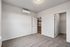 Bright, carpeted bedroom with modern air conditioning, spacious closet, and a view into a sleek kitchen.