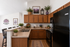 Inviting kitchen space in Bitterroot Lodge featuring rich wooden cabinets, sleek black appliances, and a cozy breakfast bar with stylish bar stools, adorned with lush greenery and elegant decor.