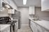 Galley kitchen with modern finishes, stainless steel appliances and gooseneck kitchen faucet.