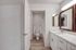 Bathroom with extended counter and vanity, white cabinets and countertops.
