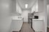 Open kitchen with white quartz countertops and white cabinets