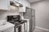 Kitchen with modern touches such as stainless steel appliances, white quartz courter tops, and white cabinetry.