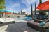 Pool area with loungers, umbrellas and fencing surrounding.