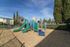 Outdoor play structure surrounded by bark and fencing.
