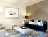 Furnished living room with royal blue couch and modern artwork